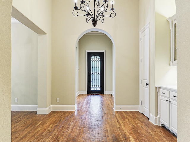 foyer with a notable chandelier and dark hardwood / wood-style flooring