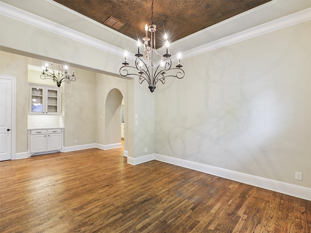 unfurnished dining area featuring ornamental molding, hardwood / wood-style floors, and a chandelier