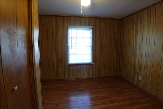 spare room with wood walls, dark hardwood / wood-style floors, and ceiling fan