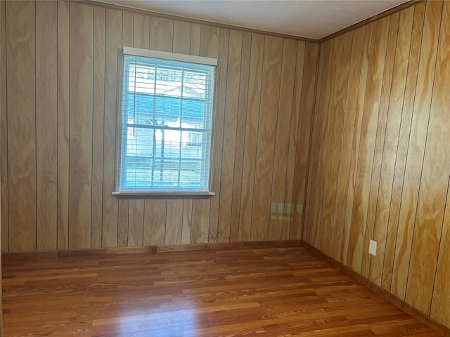 empty room featuring wood-type flooring and wooden walls