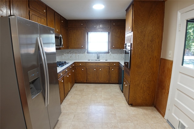 kitchen featuring decorative backsplash, appliances with stainless steel finishes, and sink