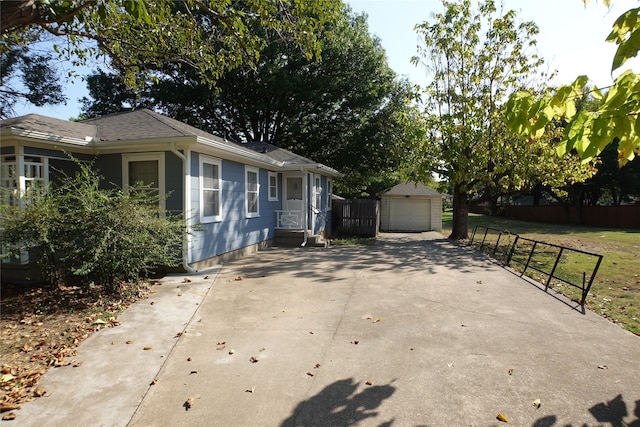 view of side of property featuring a garage, a lawn, and an outbuilding