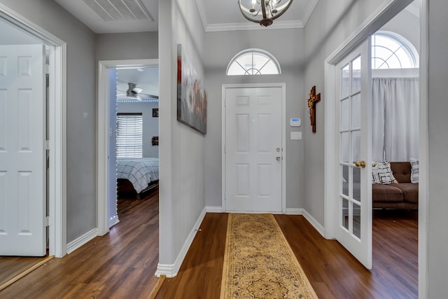 entryway featuring crown molding, a wealth of natural light, and dark wood-type flooring