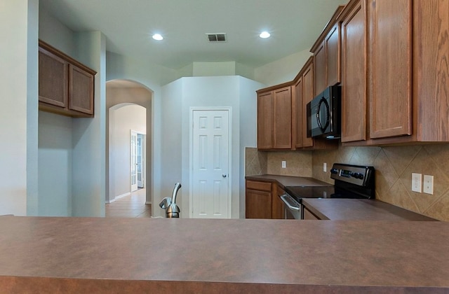 kitchen featuring decorative backsplash and stainless steel electric range oven