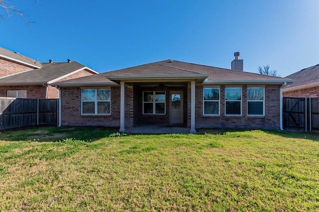 rear view of property with a patio and a yard