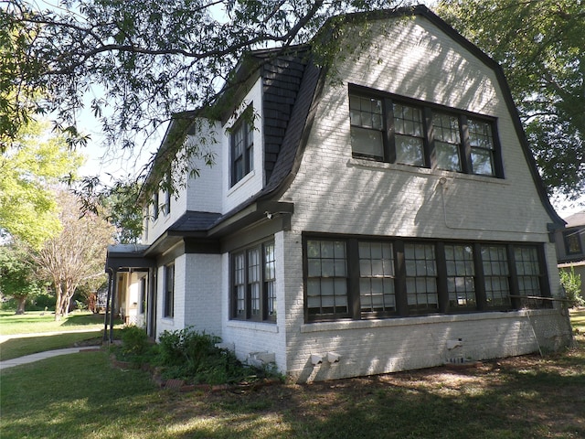 view of side of home with a lawn