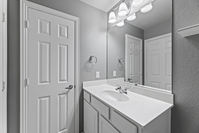 bathroom featuring a textured wall and vanity