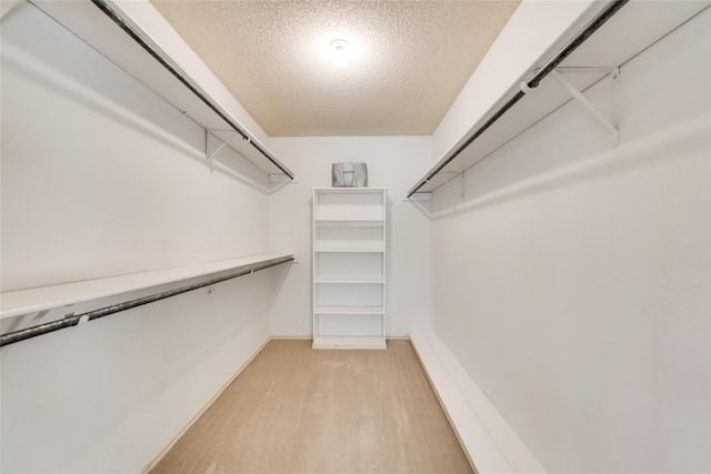 walk in closet with light hardwood / wood-style floors