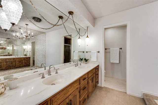 bathroom with an inviting chandelier, vanity, and toilet