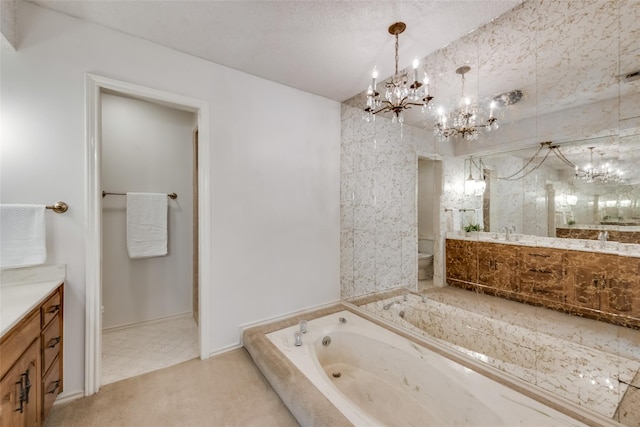 bathroom with a textured ceiling, a notable chandelier, tiled bath, vanity, and toilet