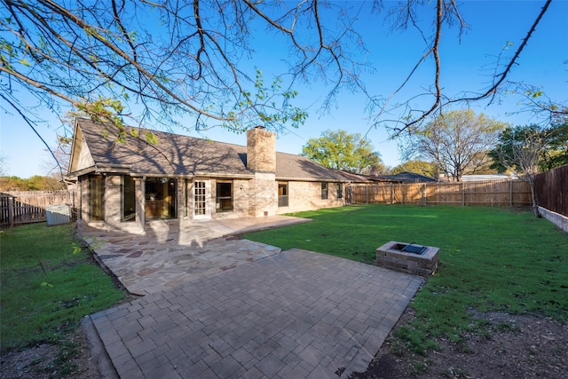 rear view of house featuring a lawn, a patio area, and french doors