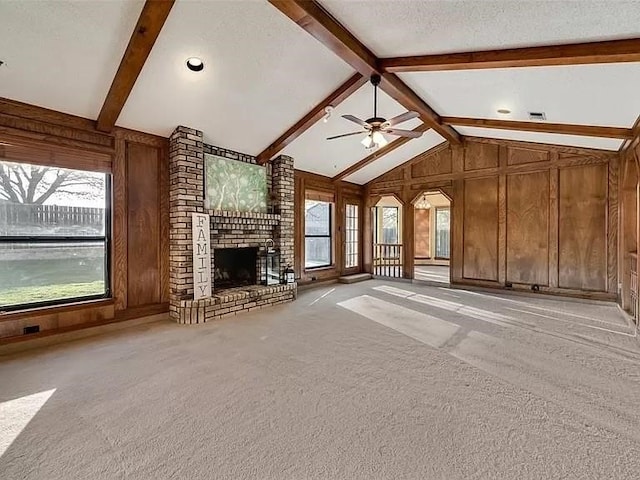 unfurnished living room featuring a textured ceiling, a healthy amount of sunlight, ceiling fan, and light carpet