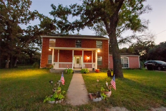 front facade featuring a porch and a lawn