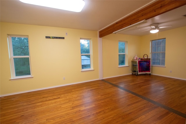 spare room featuring beamed ceiling, ceiling fan, and wood-type flooring