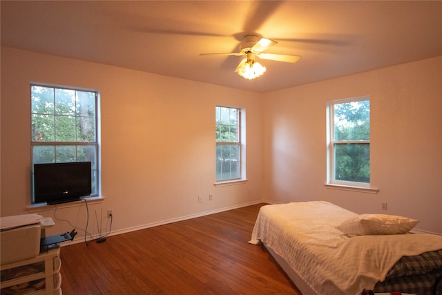 bedroom featuring wood-type flooring, multiple windows, and ceiling fan