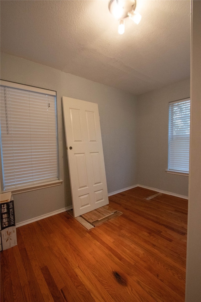 unfurnished room featuring hardwood / wood-style floors and a textured ceiling