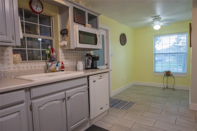 kitchen featuring ceiling fan, sink, white appliances, gray cabinetry, and backsplash