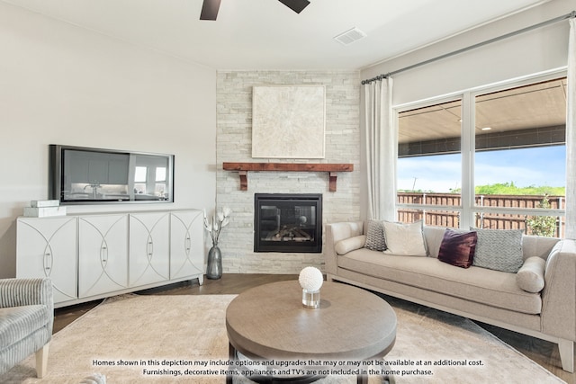 living room with a fireplace, ceiling fan, and hardwood / wood-style flooring