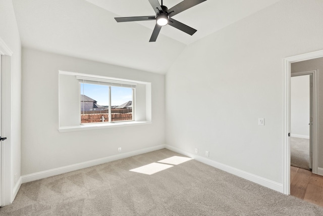 spare room with lofted ceiling, carpet flooring, a ceiling fan, and baseboards