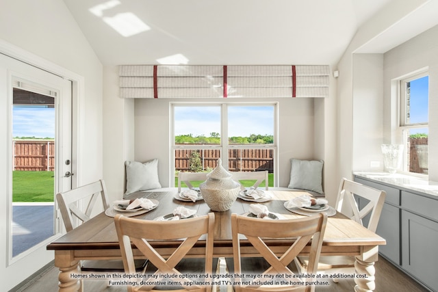 dining area featuring wood-type flooring and lofted ceiling