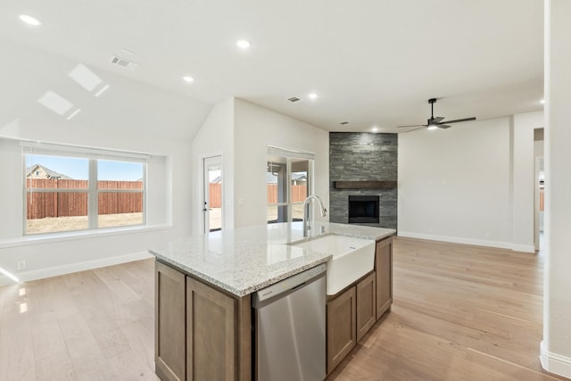 kitchen with light wood-style flooring, a fireplace, visible vents, open floor plan, and dishwasher