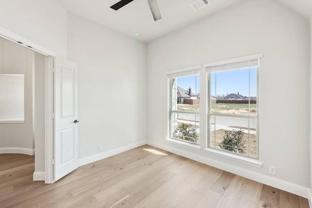 unfurnished room featuring baseboards, visible vents, and light wood-style floors