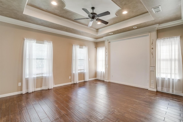 spare room with ornamental molding, wood-type flooring, ceiling fan, and a raised ceiling