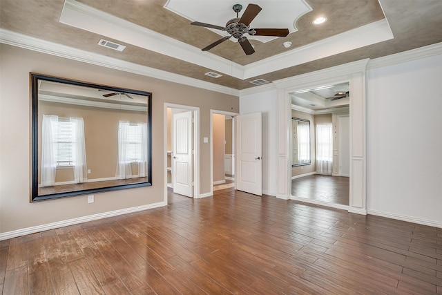 spare room featuring ornamental molding, a tray ceiling, dark hardwood / wood-style flooring, and ceiling fan