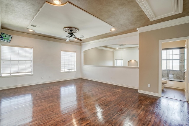 spare room with ornamental molding, a wealth of natural light, ceiling fan, and dark hardwood / wood-style floors