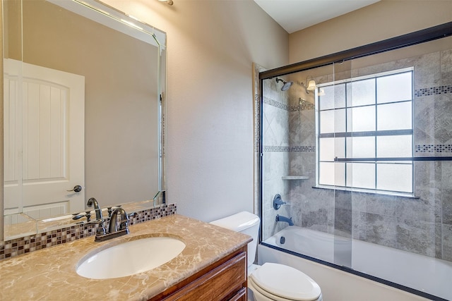 full bathroom featuring combined bath / shower with glass door, vanity, and toilet