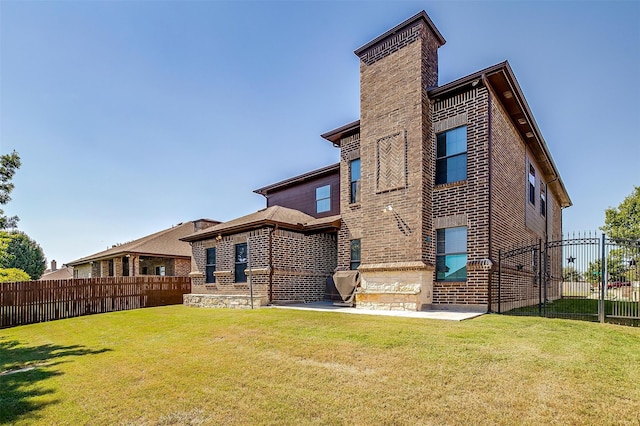 rear view of property with a lawn and a patio