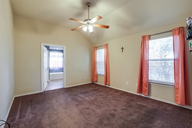 spare room featuring ceiling fan, lofted ceiling, plenty of natural light, and dark carpet