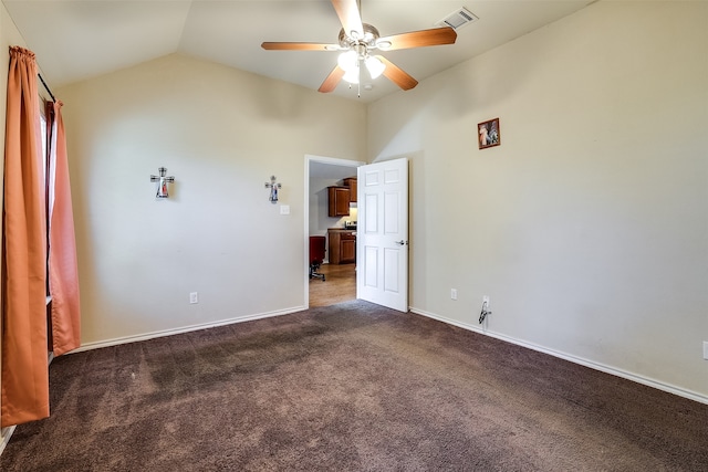 spare room featuring lofted ceiling, ceiling fan, and dark colored carpet