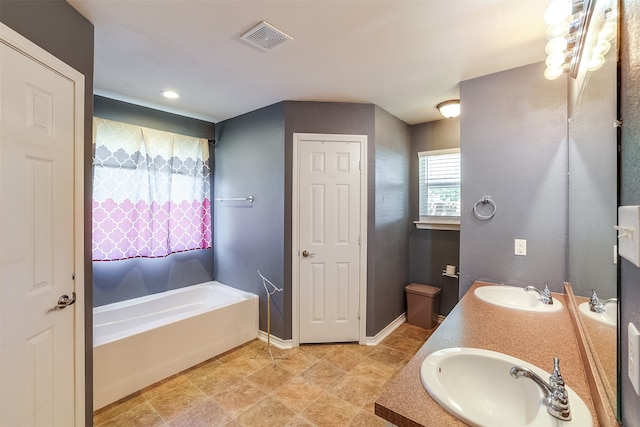 bathroom with a bathtub, tile patterned floors, and vanity