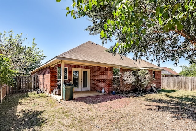 rear view of property featuring a lawn and a patio