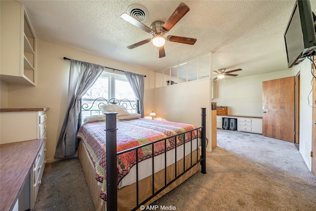 carpeted bedroom featuring built in desk, a textured ceiling, and ceiling fan