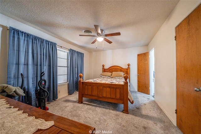 bedroom with light carpet, ceiling fan, and a textured ceiling