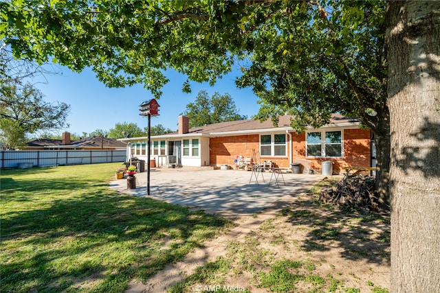 back of property with a patio and a lawn