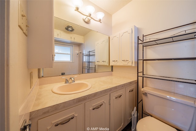 bathroom featuring vanity, toilet, and a textured ceiling