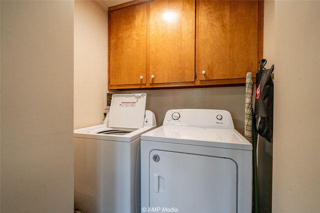 washroom featuring washing machine and dryer and cabinets