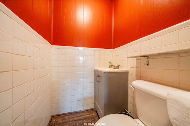 bathroom with hardwood / wood-style floors, tile walls, and toilet