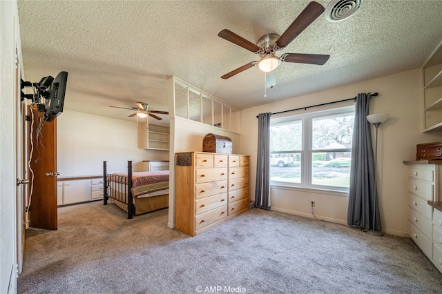 carpeted bedroom featuring ceiling fan and a textured ceiling