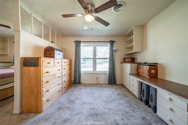 bedroom featuring ceiling fan, a textured ceiling, and light carpet