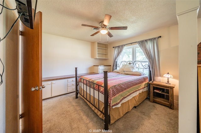 carpeted bedroom with ceiling fan and a textured ceiling