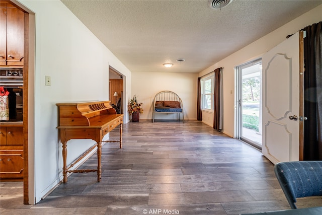 interior space with a textured ceiling and dark hardwood / wood-style flooring