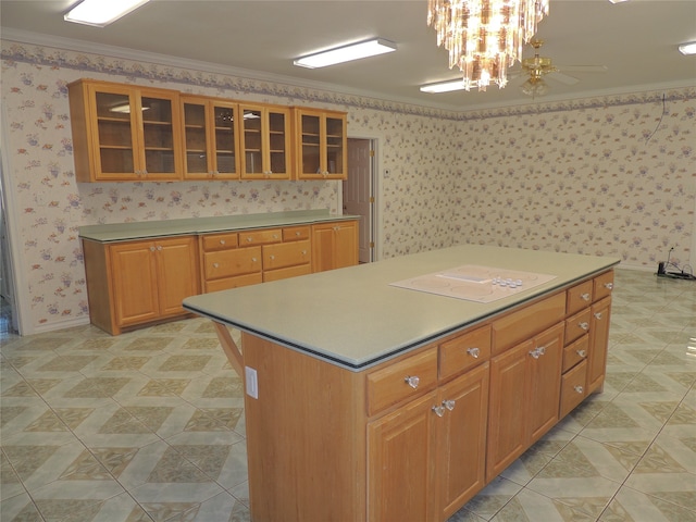 kitchen with a center island, hanging light fixtures, white electric cooktop, ceiling fan with notable chandelier, and ornamental molding