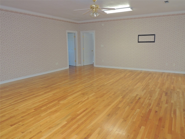 spare room featuring light wood-type flooring and crown molding