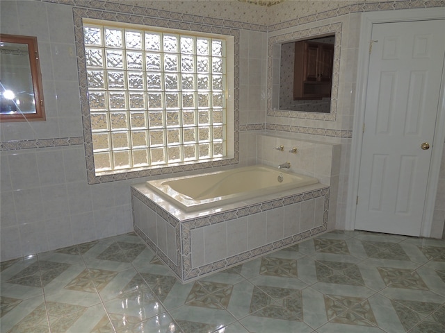 bathroom featuring tile patterned flooring, tiled bath, and tile walls