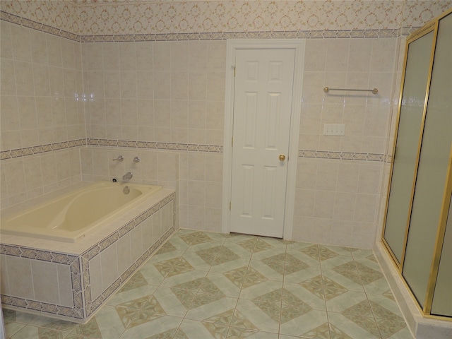 bathroom with tile patterned floors, tile walls, and independent shower and bath