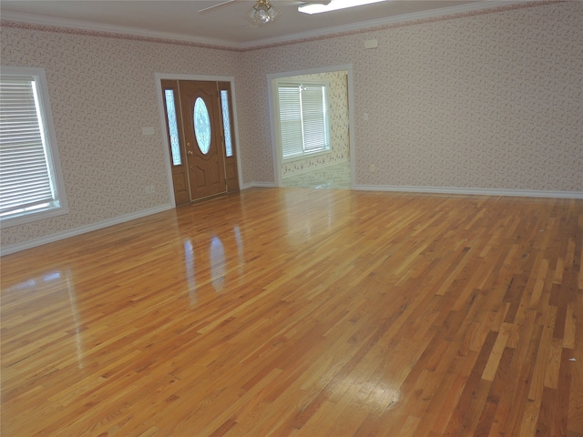 foyer entrance with light hardwood / wood-style floors, ceiling fan, and ornamental molding